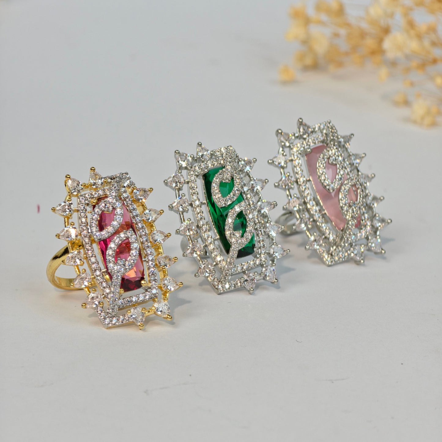 Set of decorative rings with gemstone inlays on a light gray background
