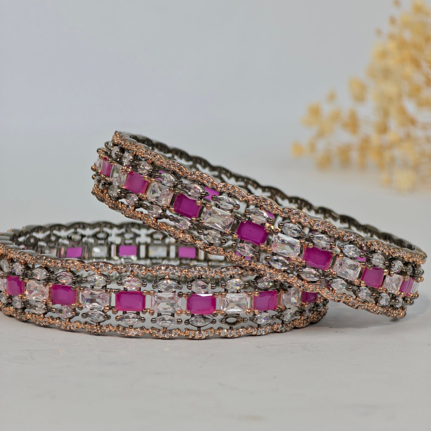 Pair of earrings with purple and clear gemstones on a light gray background