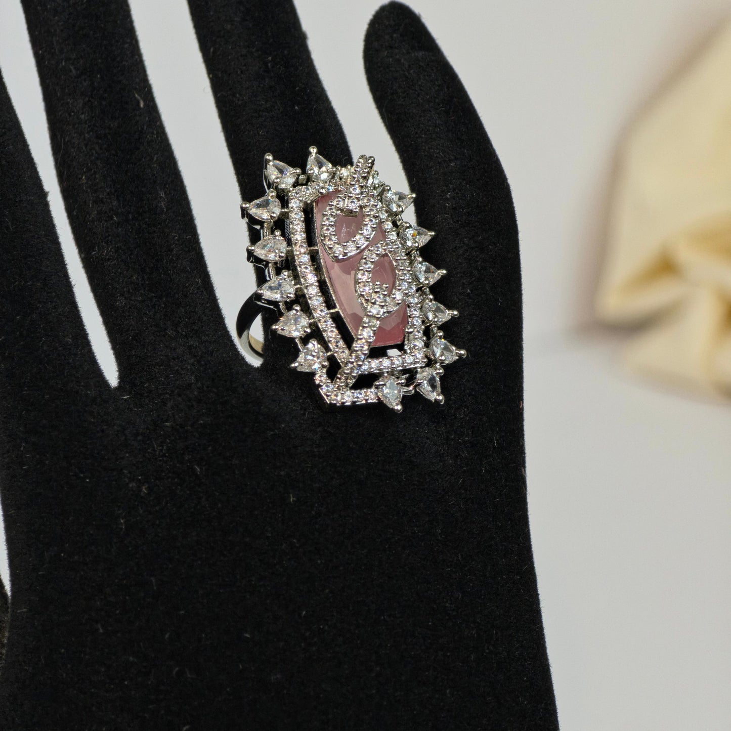 Silver ring with gemstones on a black glove