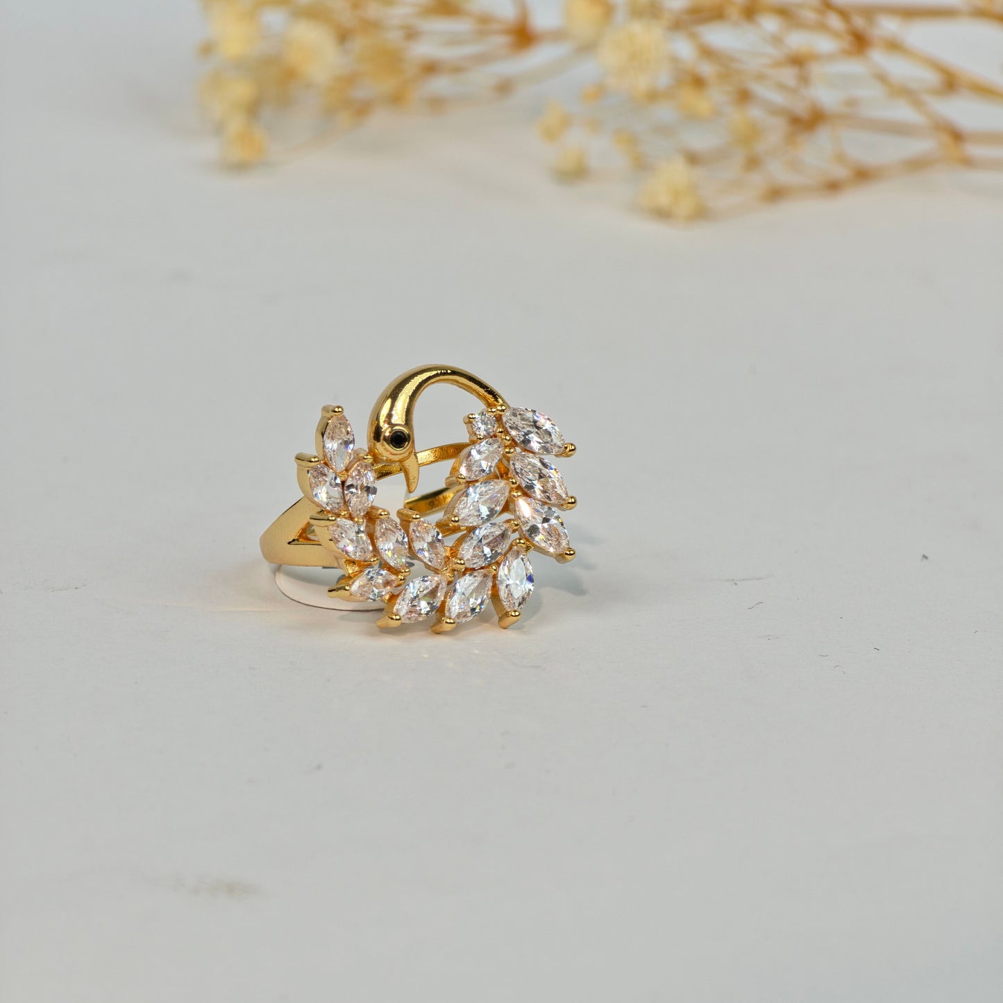 Gold ring with clear stones on a light gray background