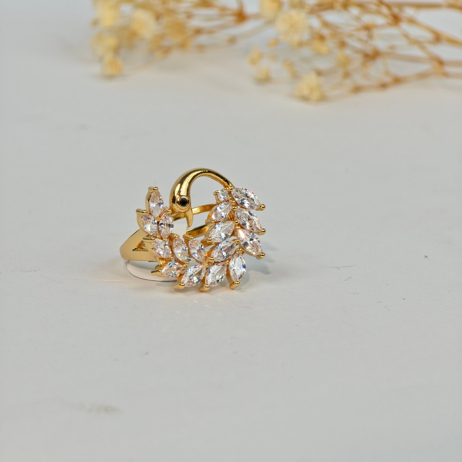 Gold ring with clear stones on a light gray background
