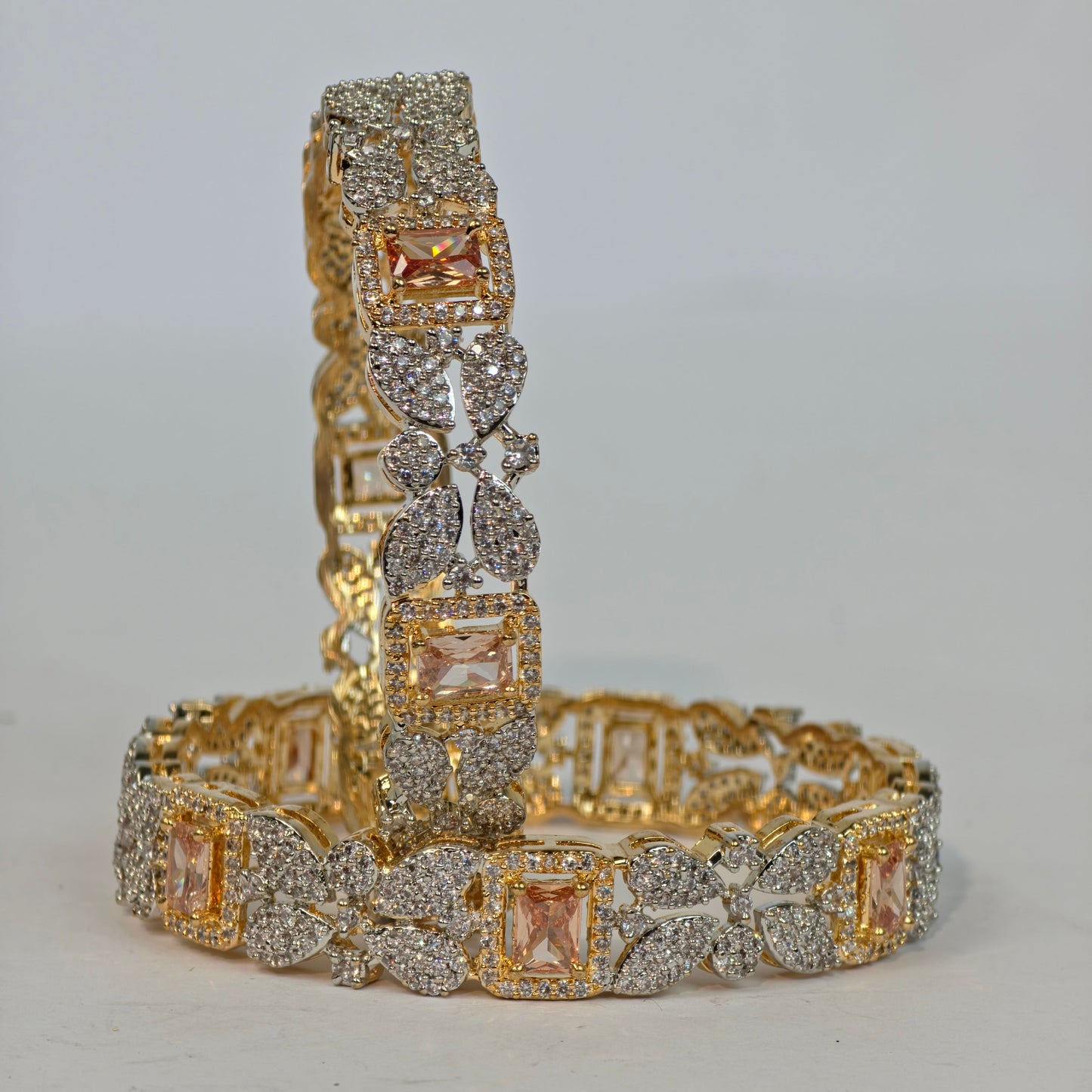 Gold and silver bracelet with diamond accents on a light gray background