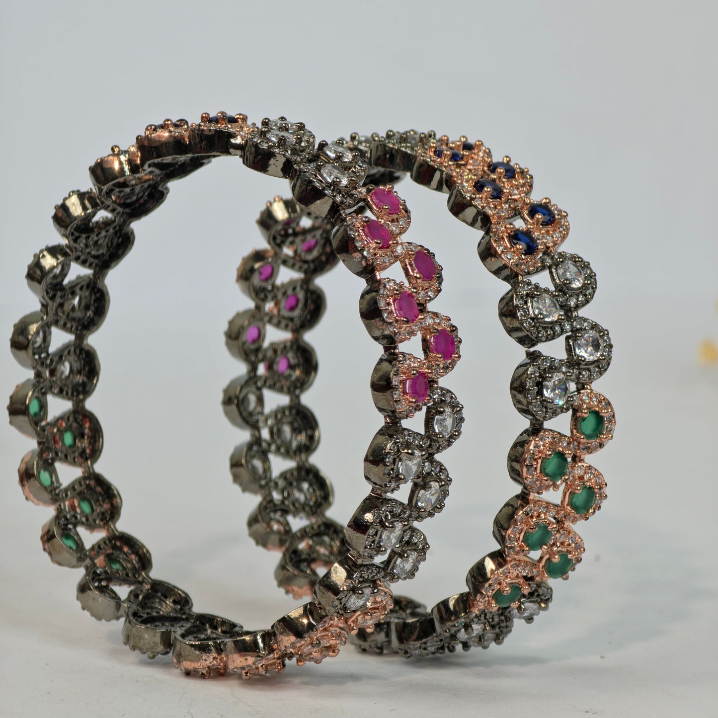 Set of three decorative bracelets with gemstones on a white background