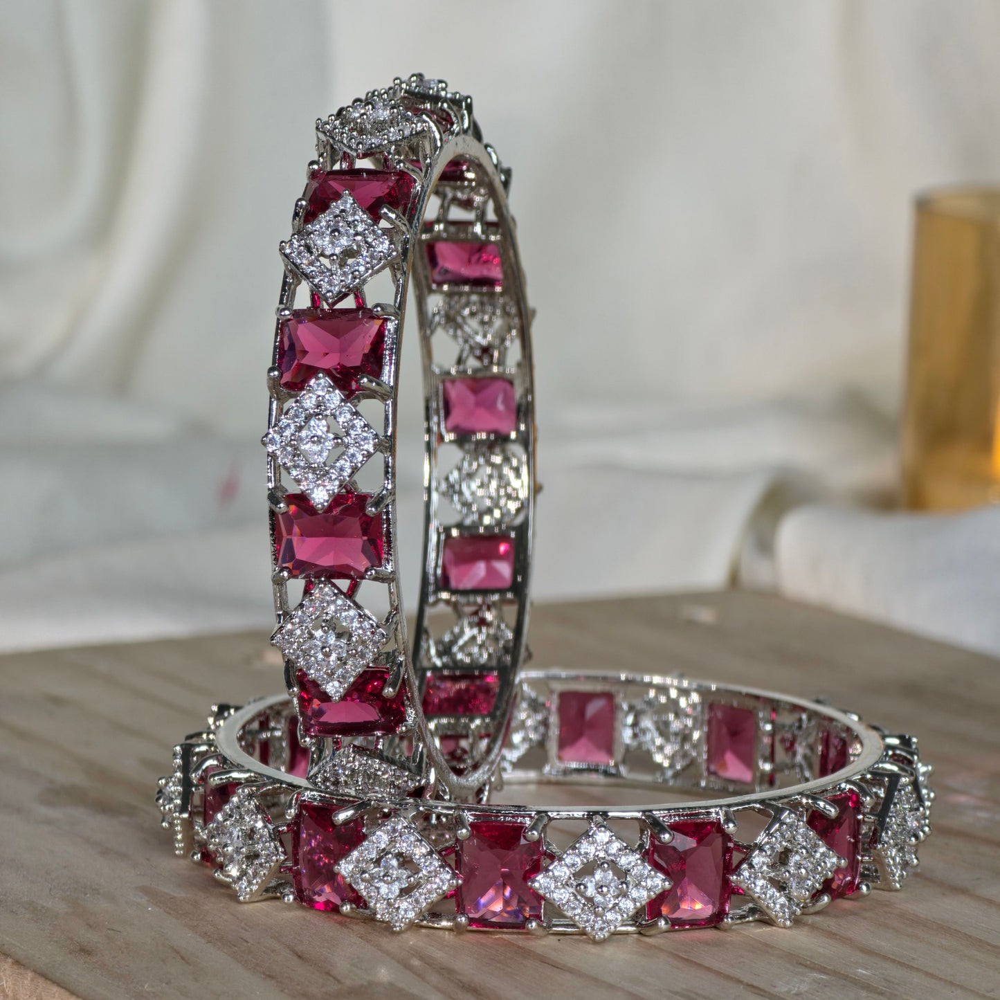 Bracelet with red gemstones and silver accents on a wooden surface