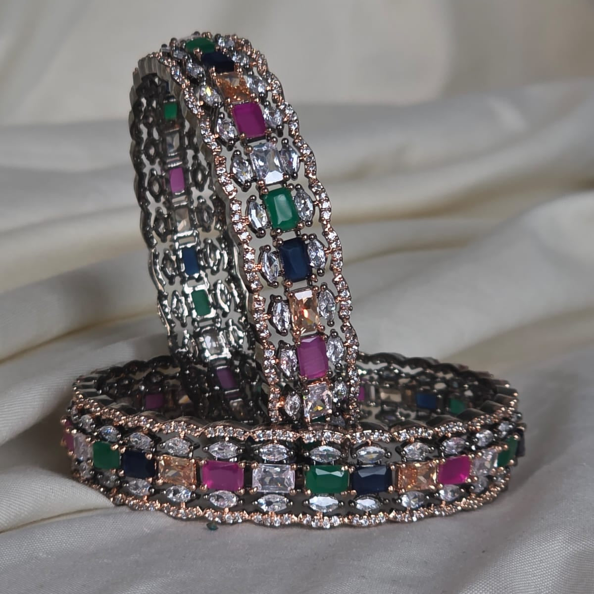 Bangles with gemstones on a light fabric background