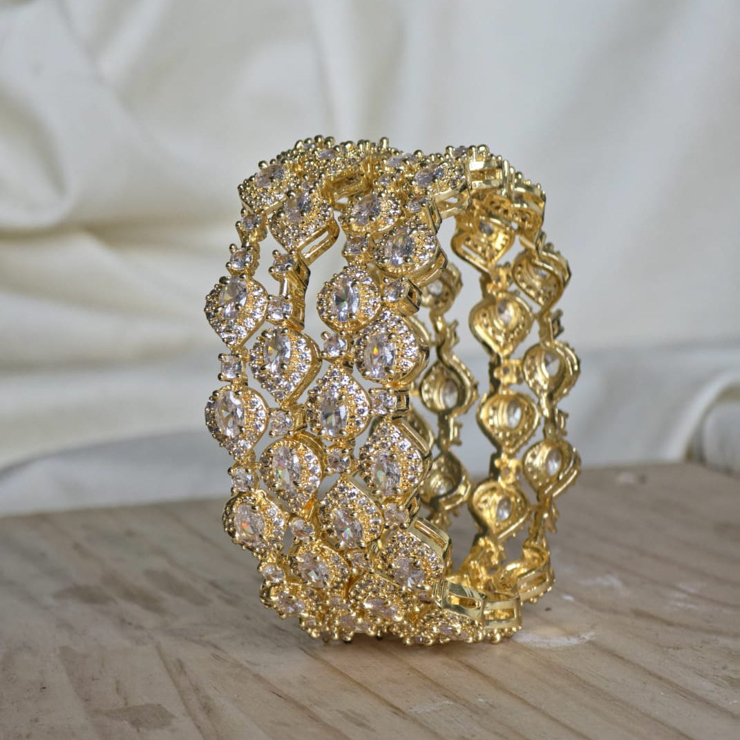 Gold bracelet with intricate design on a wooden surface