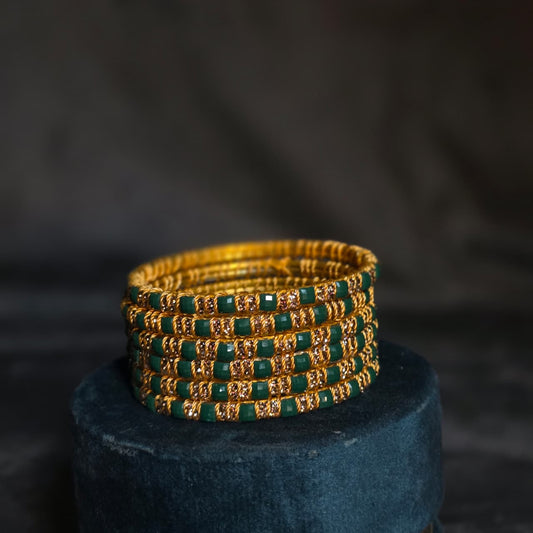 "Multicolor set of square-cut stone bangles with gold wire detailing on a wooden stand – Choori Wala by De Fleuristes."